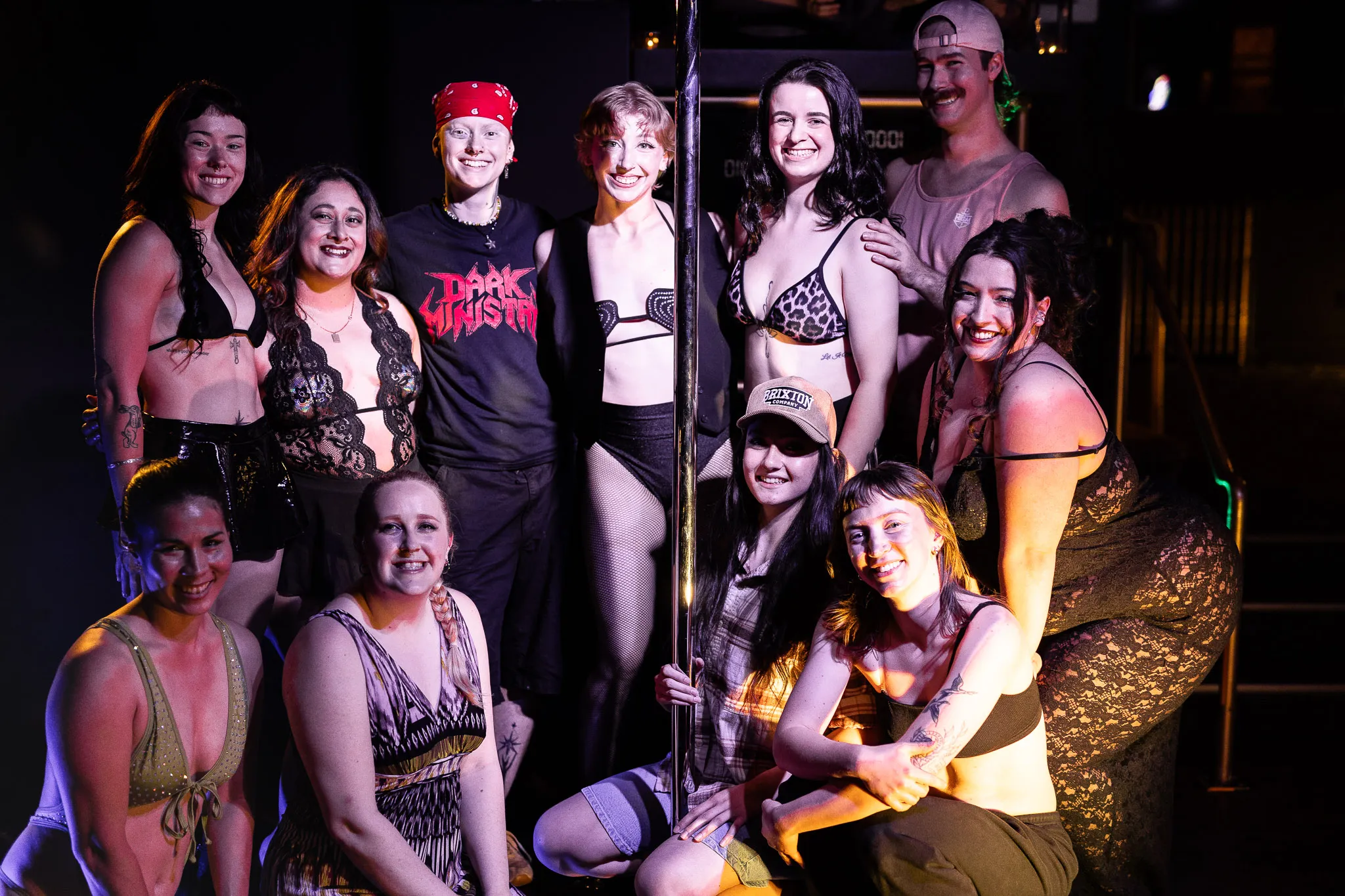 The full cast gathered around the pole after a show, smiling together